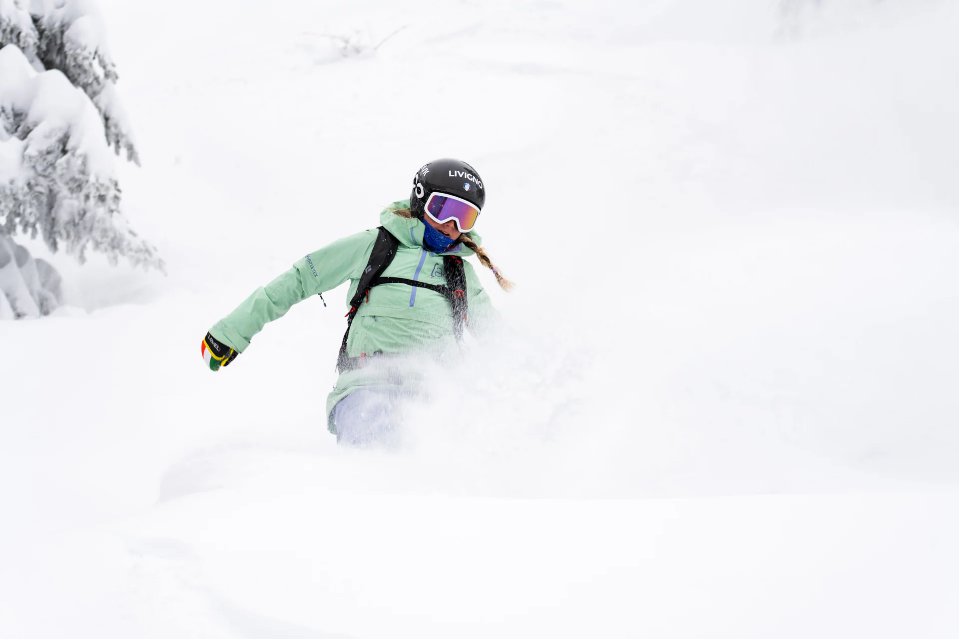Snowboarder levantando nieve polvo en un giro.